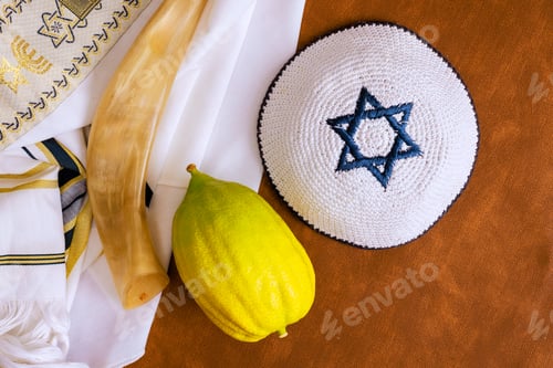 Preview: Bright etrog citrus on an ornate silver platter beside an open book Jewish fabric in cozy setting