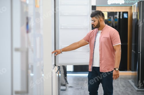 Preview: Smart modern indian male customer choosing large fridges in domestic appliances section
