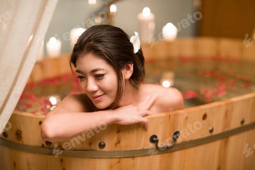Preview: Beautiful young woman in bathtub with rose petals