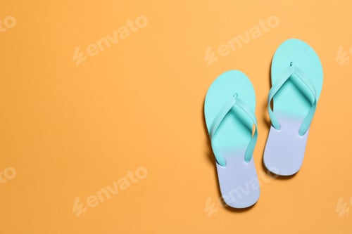 Preview: Bright flip flops on color background, top view with space for text. Beach accessories
