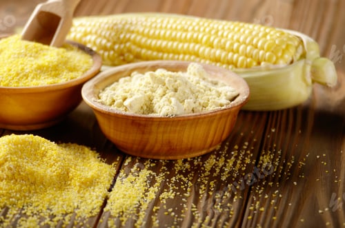 Preview: Bowl of corn grits corncob and corn flour on kitchen table