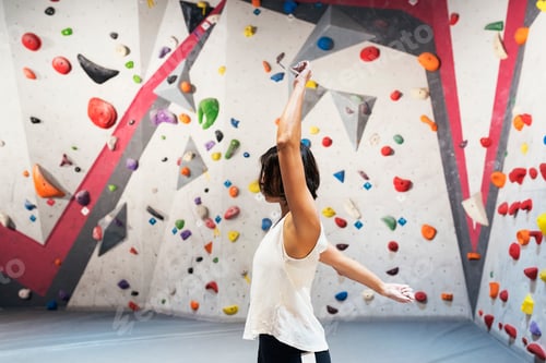 Preview: Woman training for practice rock climbing on artificial wall indoors.