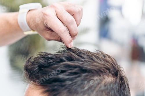 Preview: Barber fixing the hair of a client with hair gel
