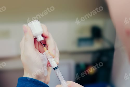 Preview: A nurse drawing up a vaccine from a vial into a syringe