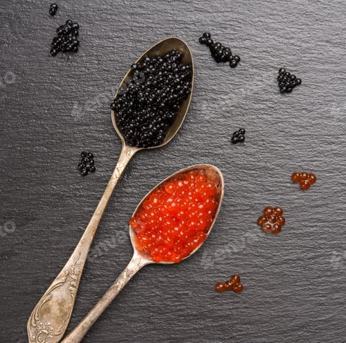Preview: Black caviar of paddlefish fish and red chum salmon caviar in a spoon, black background