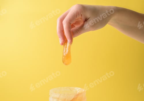 Preview: Hand with sugar wax piece from jar