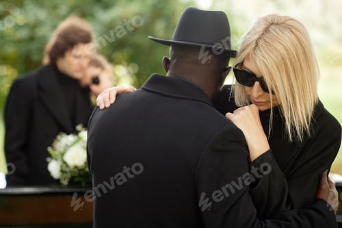 Preview: Two people embracing at outdoor funeral