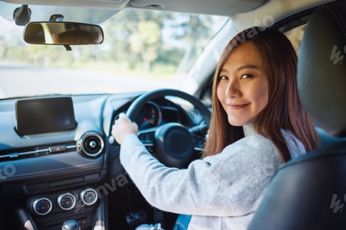 Preview: Closeup image of a woman holding steering wheel while driving a car on the road