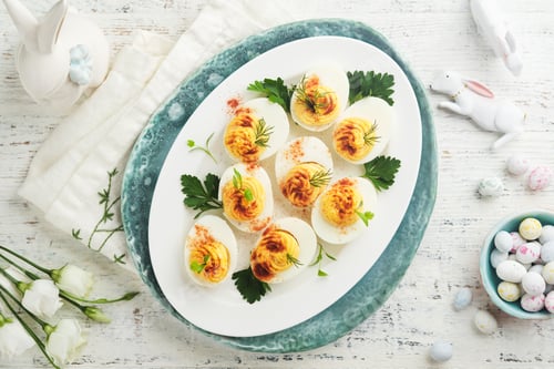 Preview: Easter stuffed eggs. Traditional Easter brunch or dinner with stuffed eggs with paprika, carrot cake