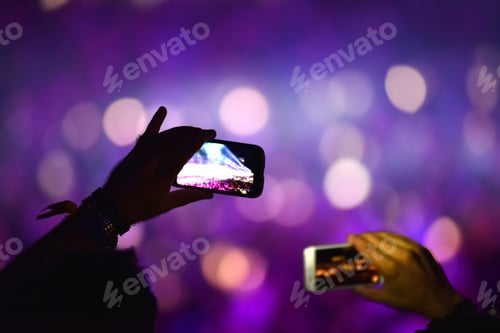 Preview: Hand holding smart phone and recording concert at music festival