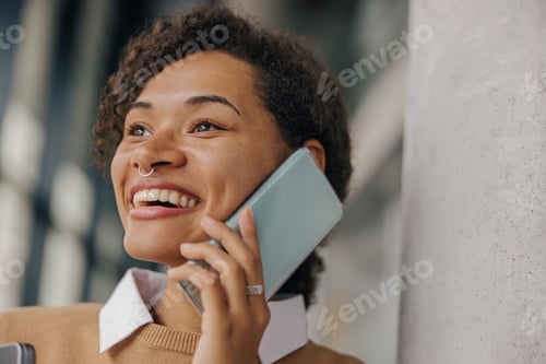 Preview: Close up of businesswoman is talking phone with client while standing on modern office background