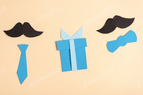 Preview: top view of paper crafted fake mustache and decorative elements on beige background, fathers day