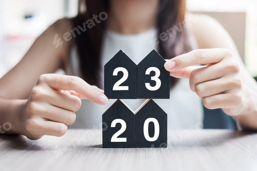 Visualização: Empresária, mãos segurando a chave e Feliz Ano Novo de 2023 com modelo de casa na mesa de escritório.
