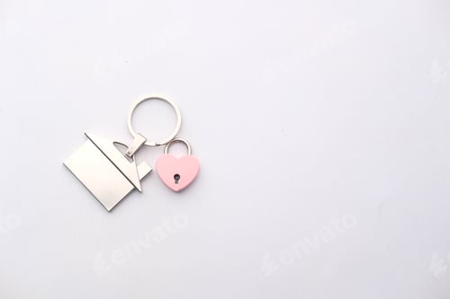 Preview: House key ring with antique key on white background. Property investment