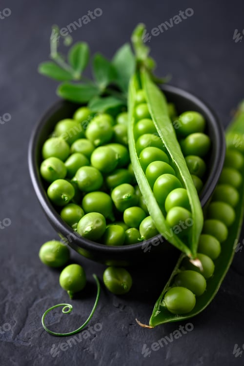 Preview: Green sugar snap peas in a bowl on black background close up