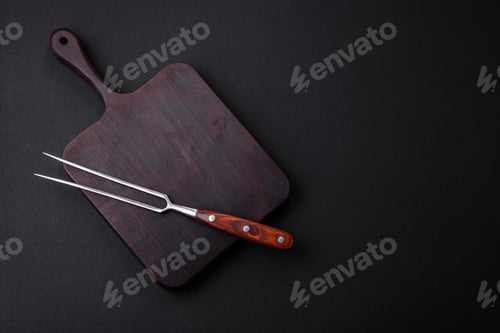 Preview: Metal kitchen fork on a dark textured concrete background