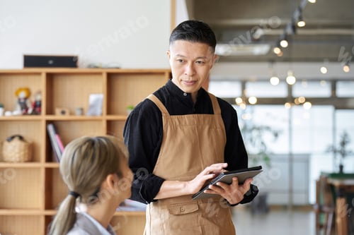 Preview: Asian male clerk taking orders at a cafe
