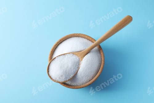Preview: Organic white salt in bowl and spoon on light blue background, top view