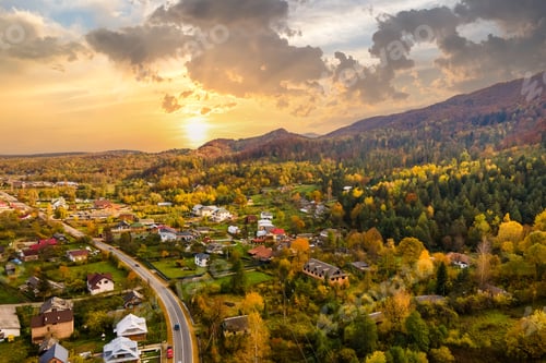 Preview: Aerial view of a rural village with small houses between autumn mountain hills