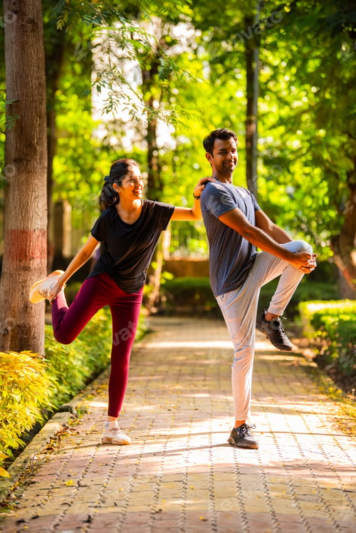 Preview: Indian beautiful young couple stretching post workout relaxing together in park outdoors