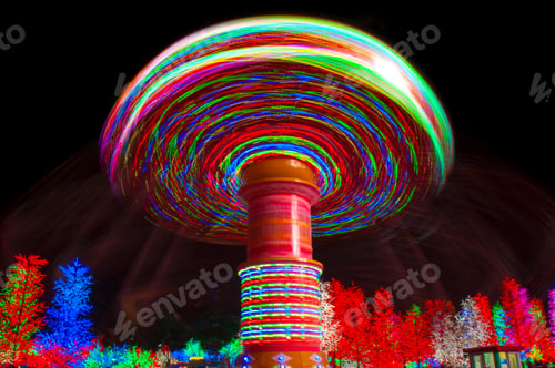 Preview: Carnival amusement park ride with swings. Spinning fair ride at night with bright color lights
