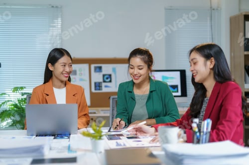 Preview: Asian businesswomen working together analyzing financial charts in modern office
