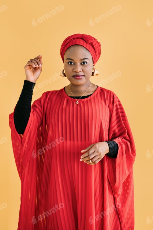 Preview: Portrait of a beautiful young African lady in a red dress, a turban on her head and in jewelry
