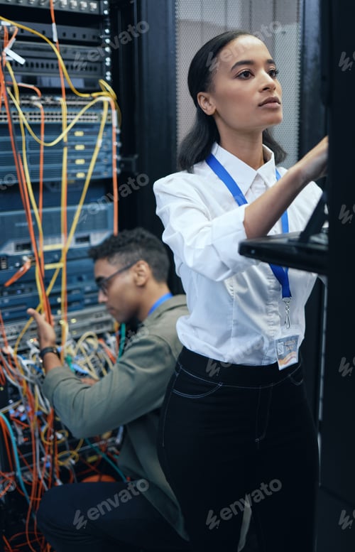 Preview: Cropped shot of two young computer programmers working together in a server room