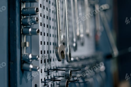 Preview: close up at service station there is board on the wall with wrenches and other tools hanging on it