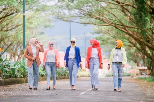 Preview: Stylish Women Walking Down a Tree-lined Street