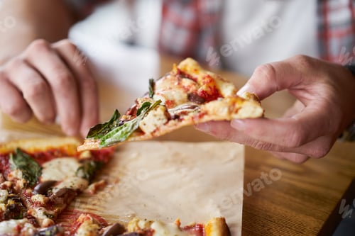 Preview: close up of man eating a slice of authentic brick oven fired pizza