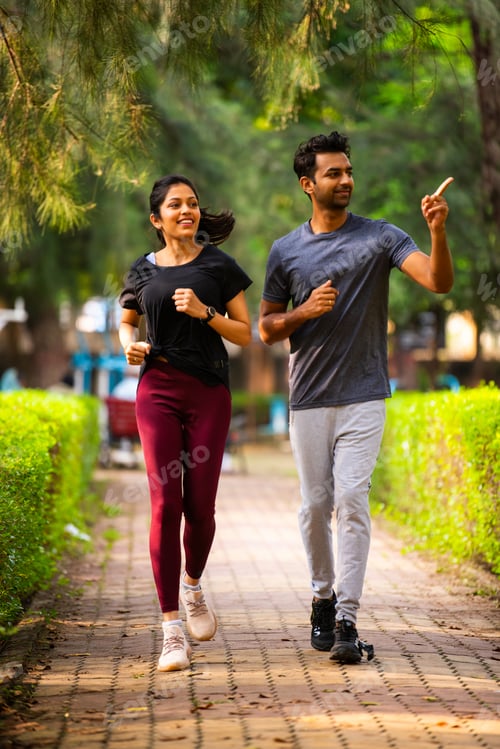 Preview: Indian young couple jogging in park enjoying morning fitness, outdoor freshness and bonding