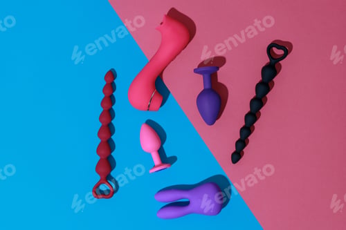 Preview: Top view of buttplugs and dildos vibrator for sex on colored background. Sex shop concept