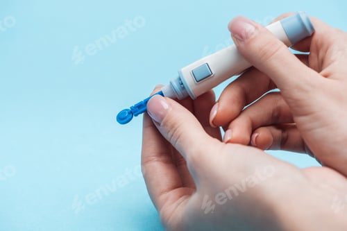 Preview: cropped view of woman testing glucose level with disposable needle on blue background