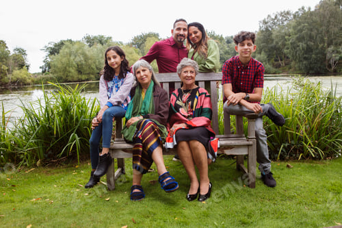 Preview: Family enjoying a day out in the park, sitting together on a bench