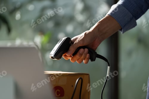 Preview: Focused small business owner using a handheld barcode scanner to process packages in a startup