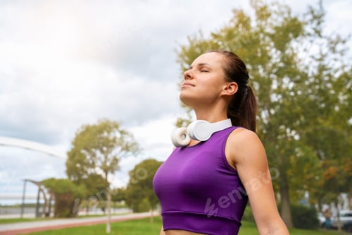 Preview: Fitness woman breathes in fresh air during outdoor workout.
