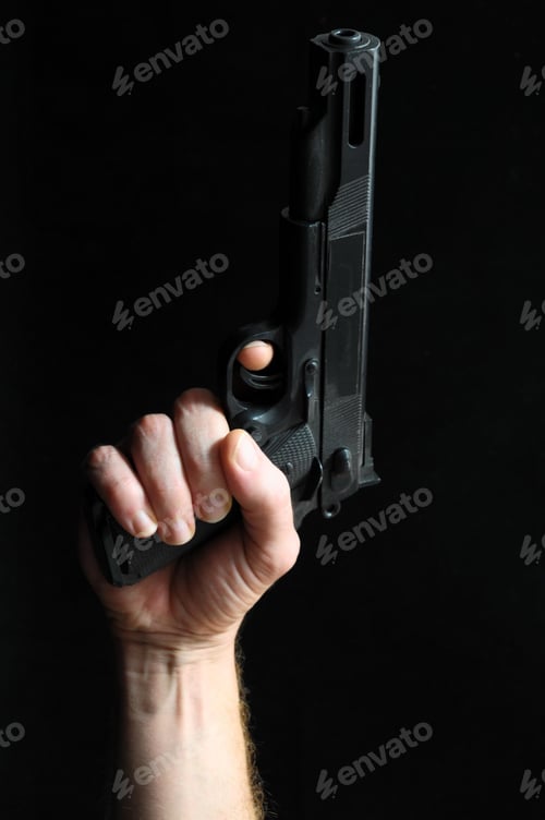 Preview: Closeup of a person holding a gun upwards on a black background