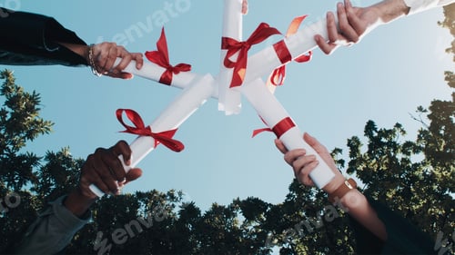 Preview: Shot of a group of students standing in a huddle with their diplomas on graduation day