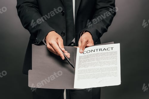 Preview: partial view of african american businessman showing contract on dark background