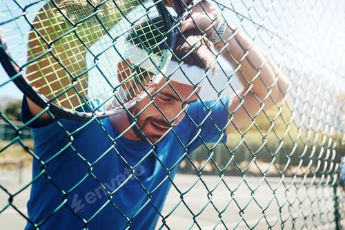 Preview: Cropped shot of a handsome young sportsman taking a moment to breathe during tennis practise