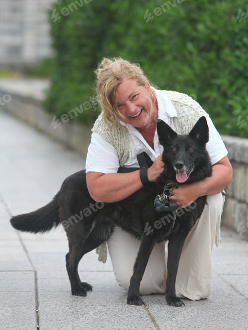 Preview: Happy Mature Woman Enjoying Time With Her Dog Outdoors