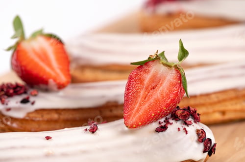Preview: delicious eclair with icing and whipped cream filling, French dessert with strawberries, closeup