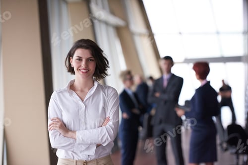 Preview: Smilling Young Business Woman In Front Her Team Blured In Background. Group Of Young Business