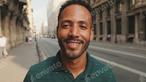 Preview: Close-up of happy young man standing on the street. Guy turns his head and smiles at the camera
