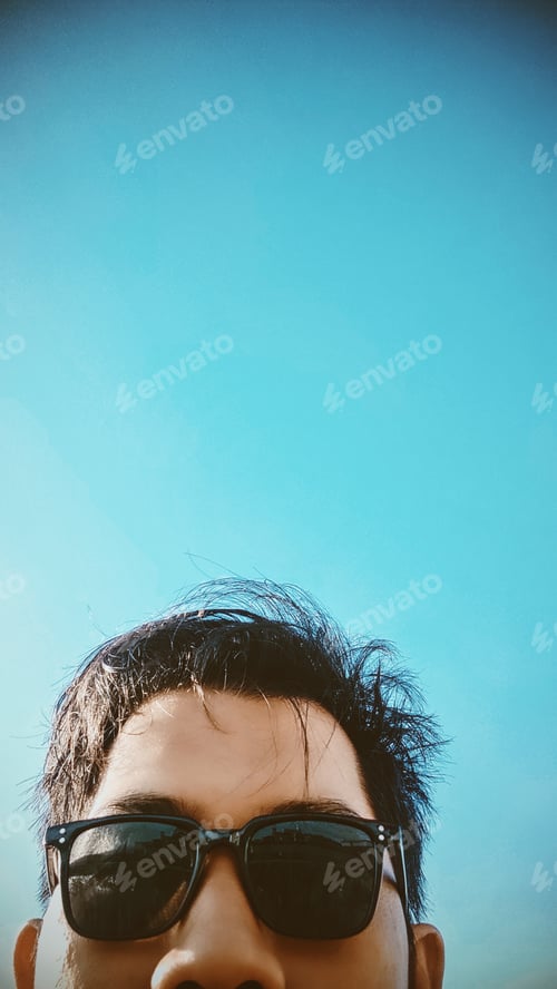 Preview: Man Wearing Sunglasses Against a Blue Sky