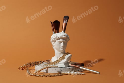 Preview: Jewelry and makeup concept with ancient head on brown background