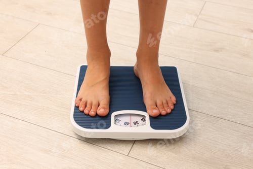 Preview: Little boy standing on scales indoors, closeup