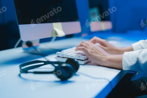 Preview: Office worker typing on keyboard in modern office at night