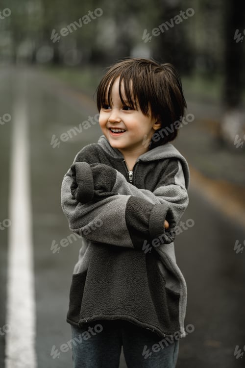 Preview: A little boy is standing alone on the street